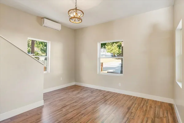an empty room with wooden floor and window