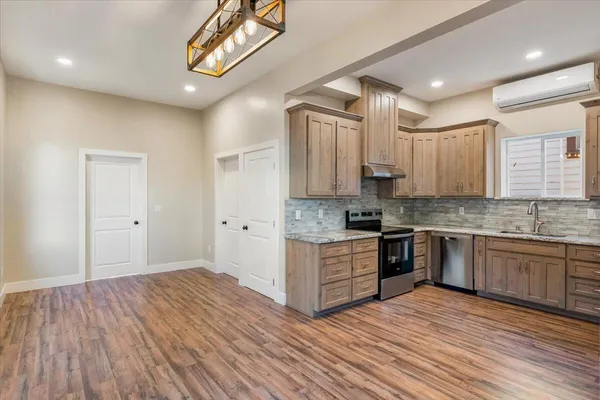 a large kitchen with cabinets wooden floor and stainless steel appliances