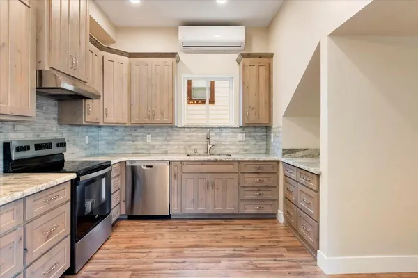 a kitchen with granite countertop a sink stainless steel appliances and cabinets