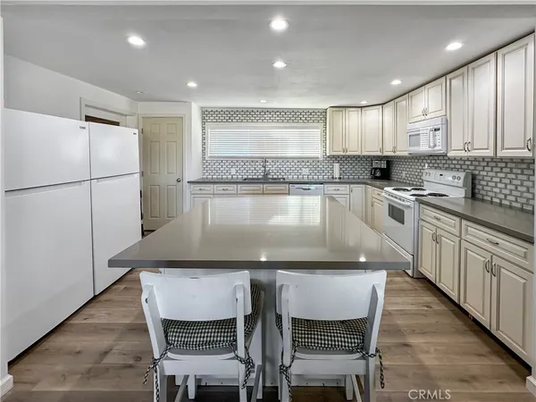 a large kitchen with stainless steel appliances granite countertop a lot of counter space and wooden floors