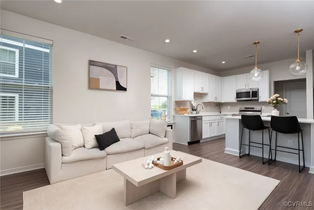 a living room with furniture and kitchen view