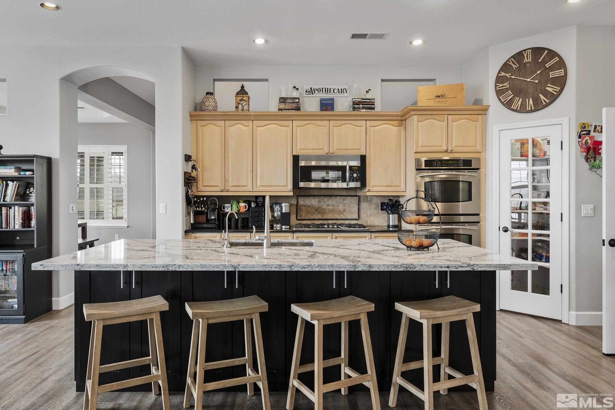 5630 North White Sands Road Reno, NV 89511 - Photo 11 of 40 a kitchen with stainless steel appliances granite countertop a table chairs sink and cabinets