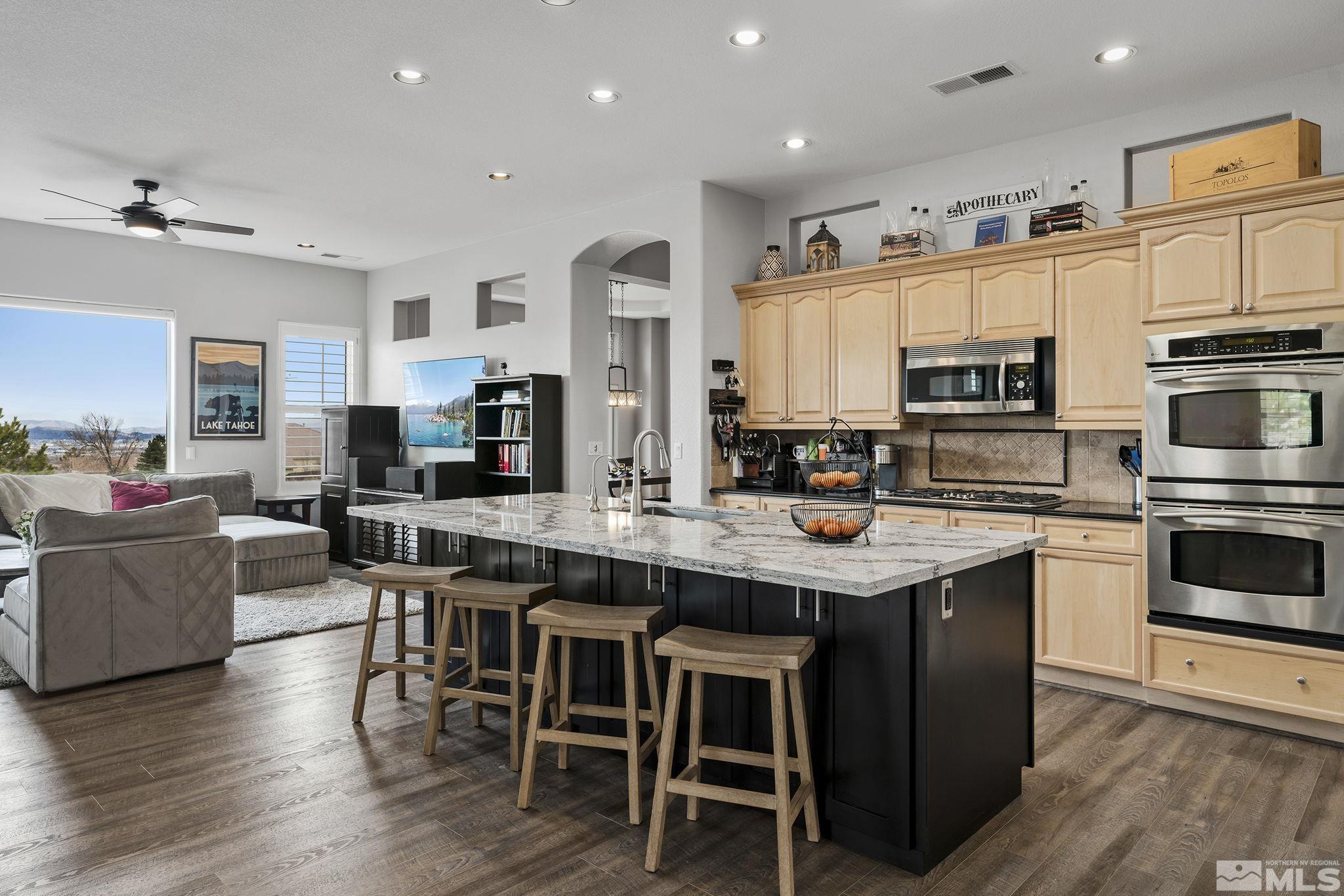 5630 North White Sands Road Reno, NV 89511 - Photo 12 of 40 a kitchen with stainless steel appliances granite countertop a table chairs microwave and cabinets