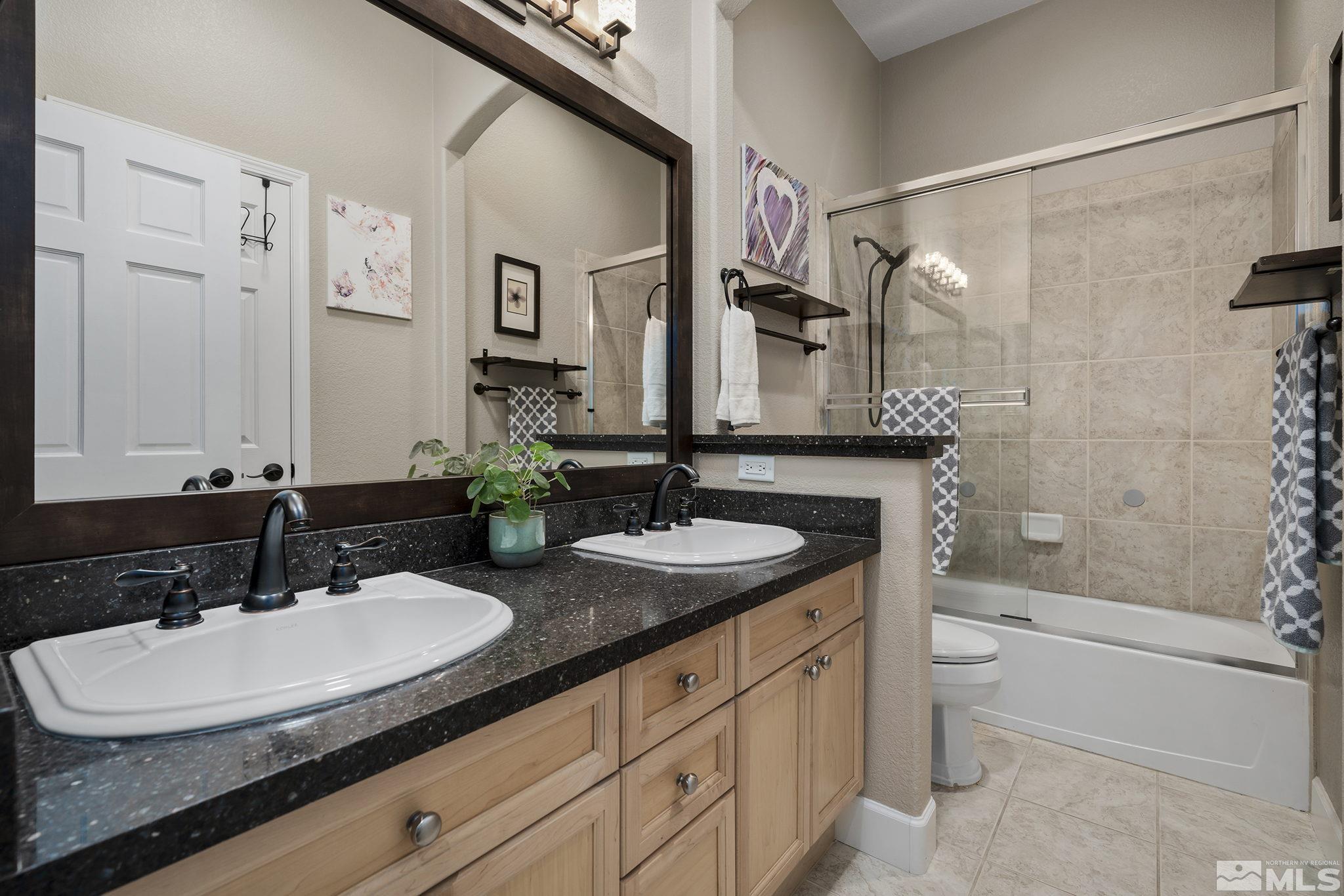 5630 North White Sands Road Reno, NV 89511 - Photo 21 of 40 a bathroom with a sink double vanity granite tub shower and a mirror