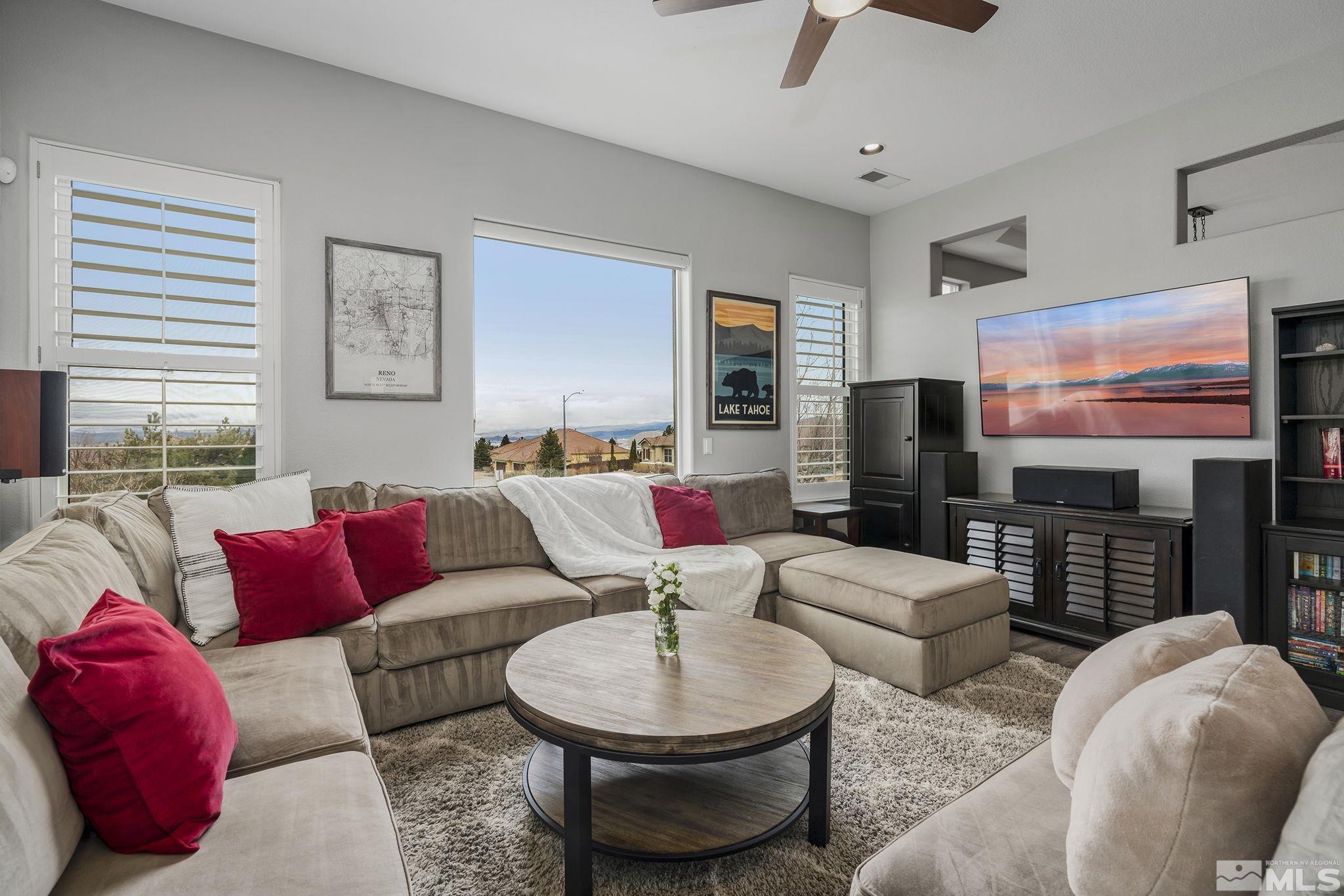 5630 North White Sands Road Reno, NV 89511 - Photo 7 of 40 a living room with furniture a flat screen tv and a large window