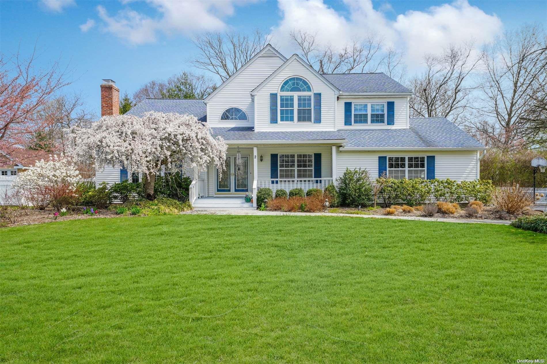 a front view of a house with garden and trees