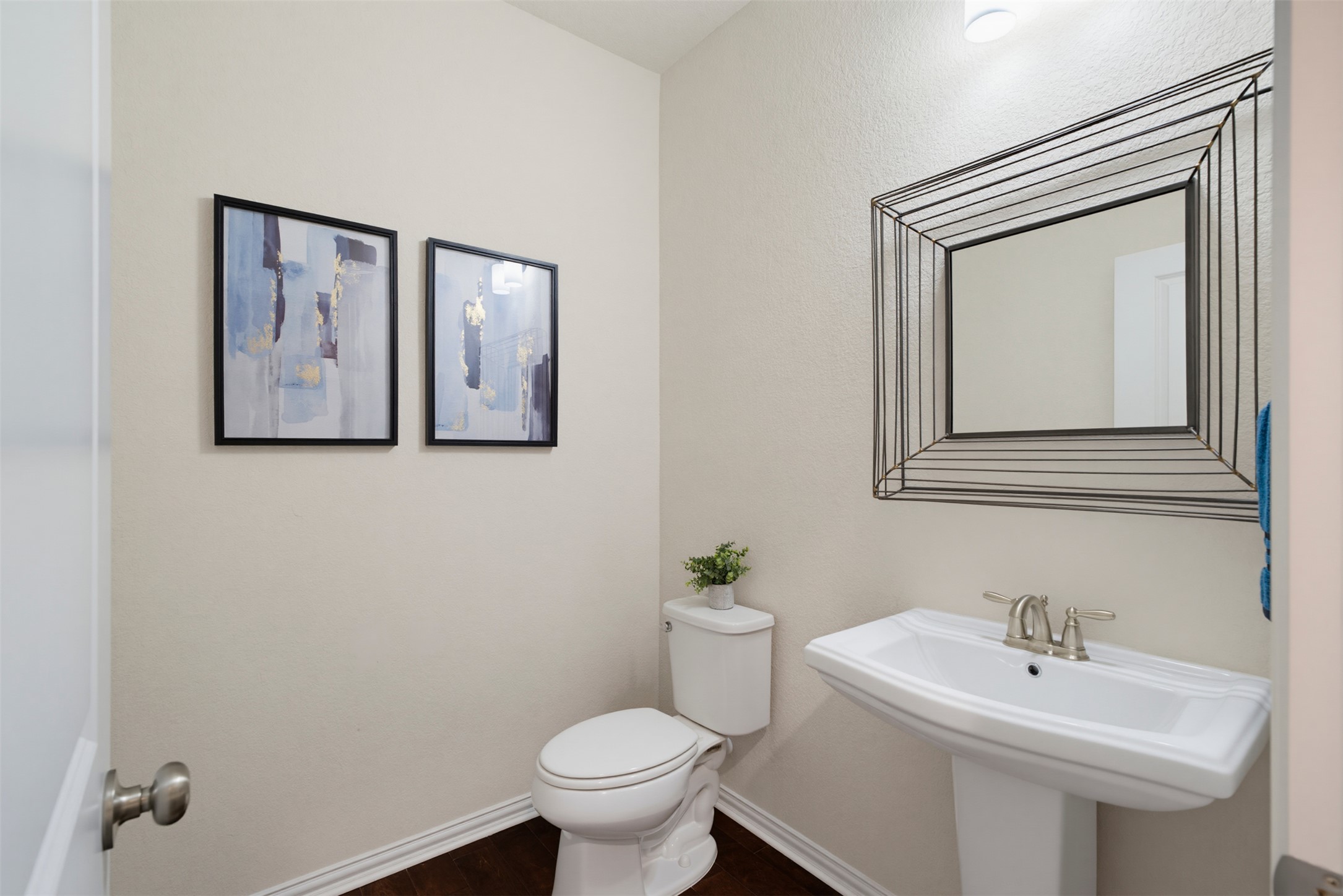 12613 Twisted Root Drive Manchaca, TX 78652 - Photo 24 of 33 A compact powder room with a pedestal sink and rich wood flooring offers essential convenience.