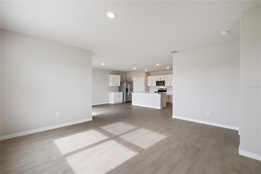 9498 Turtle Grass Circle Punta Gorda, FL 33950 - Photo 3 of 21 a view of a kitchen with kitchen island white cabinets and wooden floor