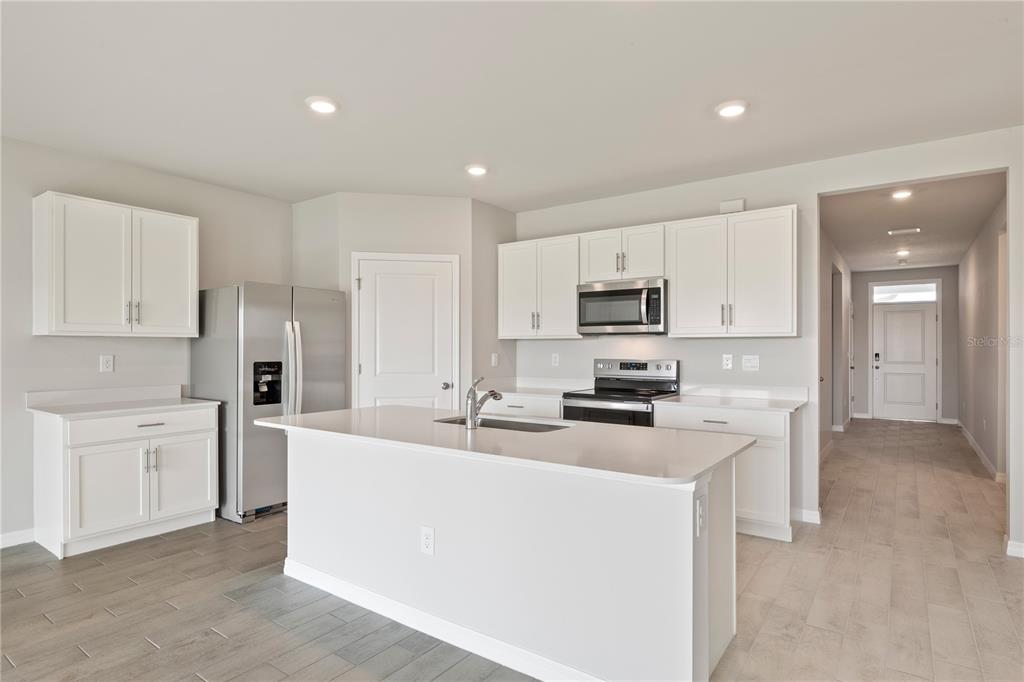 9498 Turtle Grass Circle Punta Gorda, FL 33950 - Photo 5 of 21 a kitchen with white cabinets and stainless steel appliances