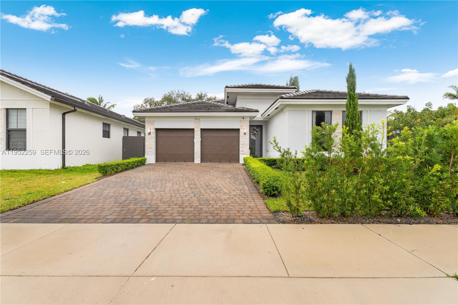 19410 Southwest 124th Court Miami, FL 33177 - Photo 26 of 33 a front view of a house with a yard and potted plants
