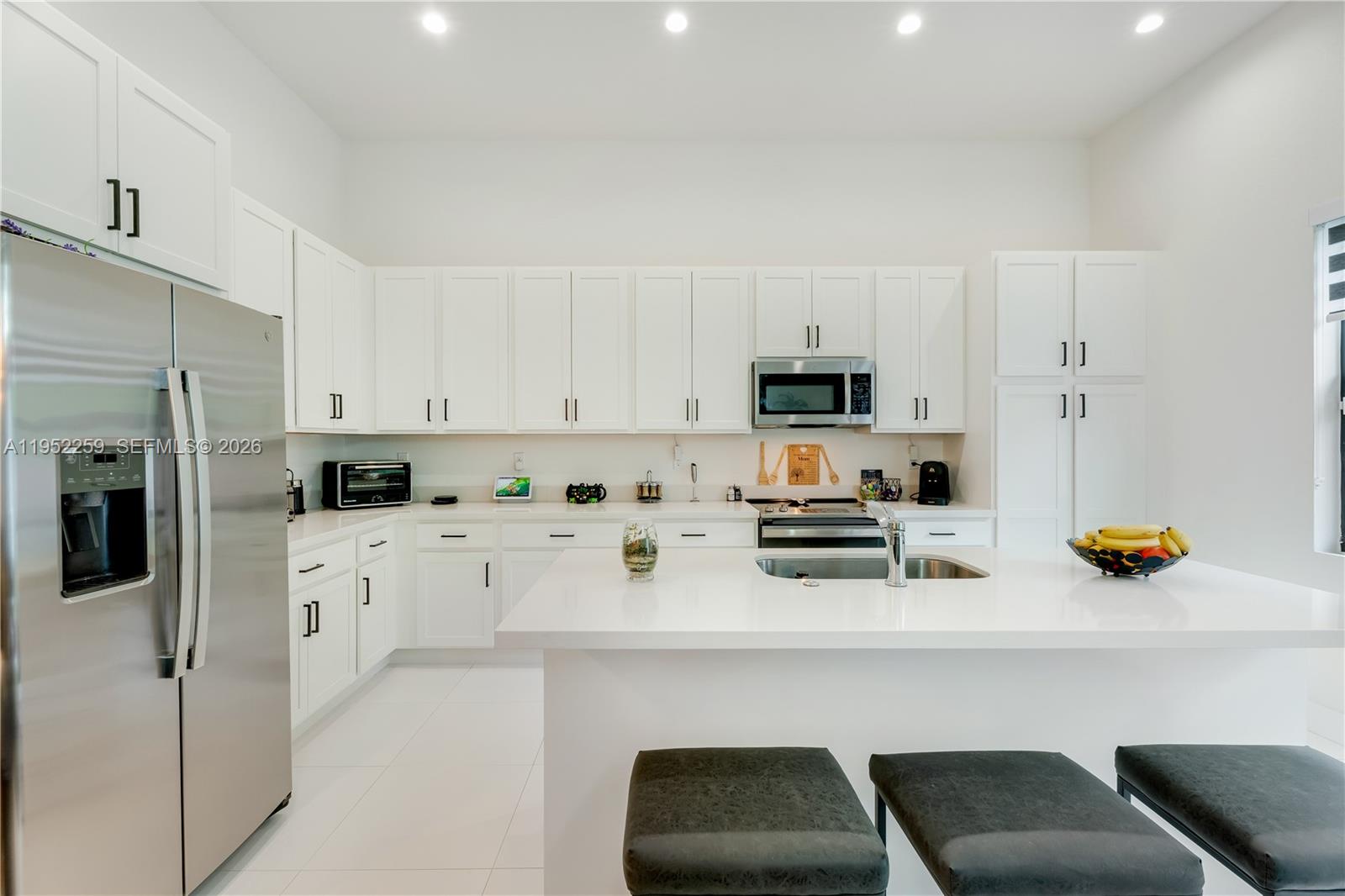 19410 Southwest 124th Court Miami, FL 33177 - Photo 10 of 33 a kitchen with stainless steel appliances a stove a sink a refrigerator a stove a microwave and cabinets