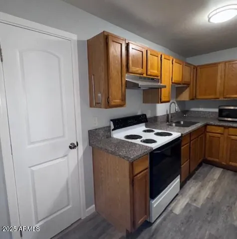 a kitchen with a sink stove top oven and cabinets