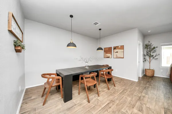 a view of a patio with table and chairs potted plants with floor to ceiling window and potted plants