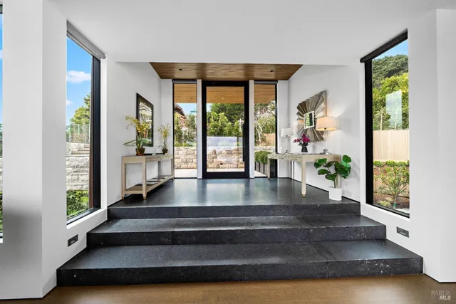 a living room with couches bookshelf and a large window
