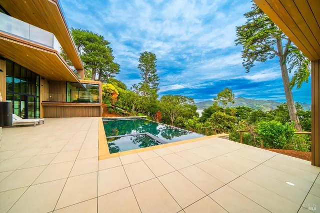 a view of a house with pool and sitting area