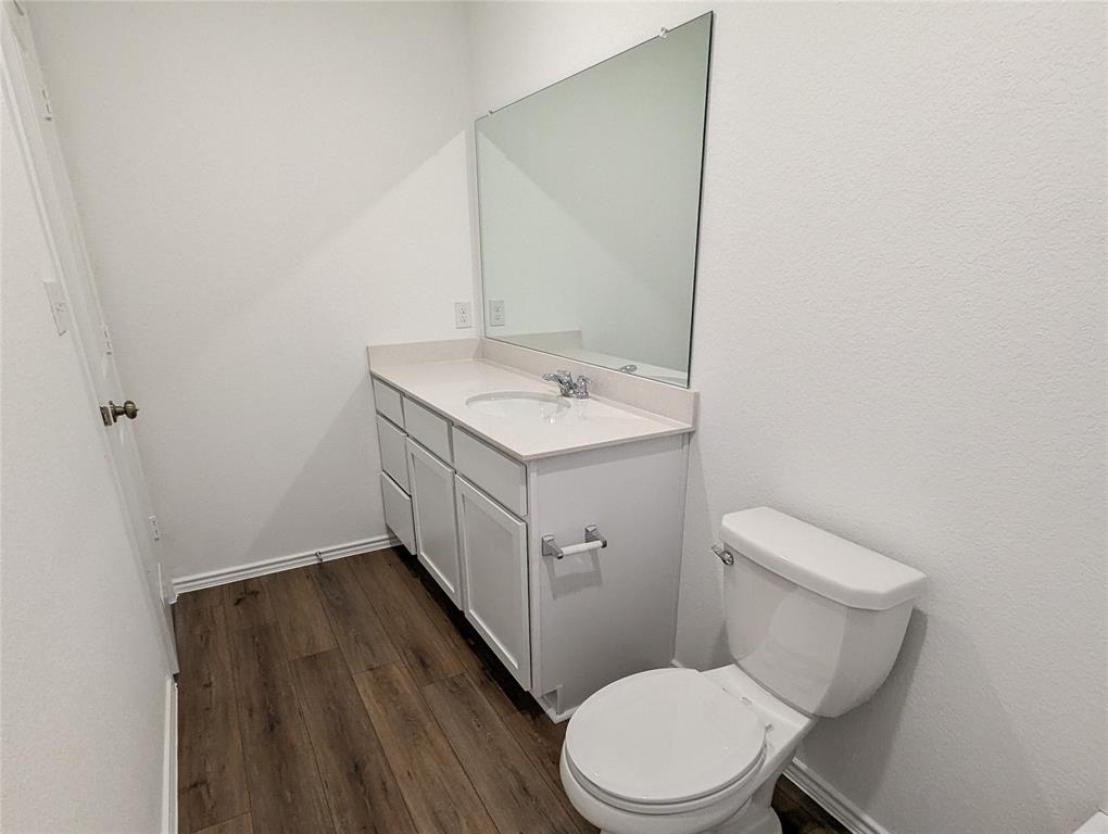 152 Avre Loop Kyle, TX 78640 - Photo 12 of 24 A well-appointed half-bath offers convenience and style with its sleek vanity and rich hardwood flooring.