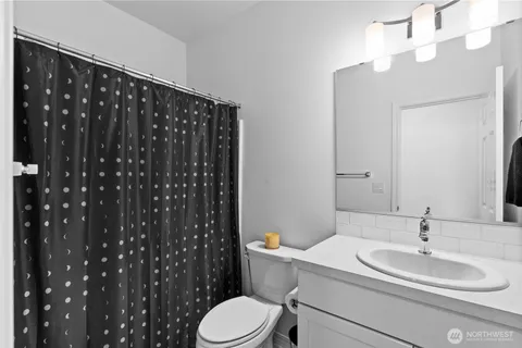 a bathroom with a sink vanity mirror and toilet