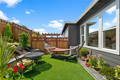 a view of a chair and tables in the back yard of the house