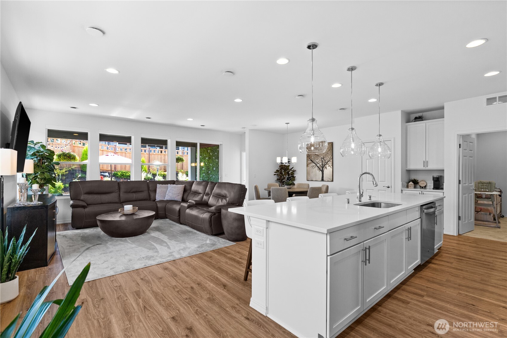15215 182nd Avenue East Bonney Lake, WA 98391 - Photo 10 of 40 a view of a kitchen with kitchen island a large counter top space a sink stainless steel appliances and living room view