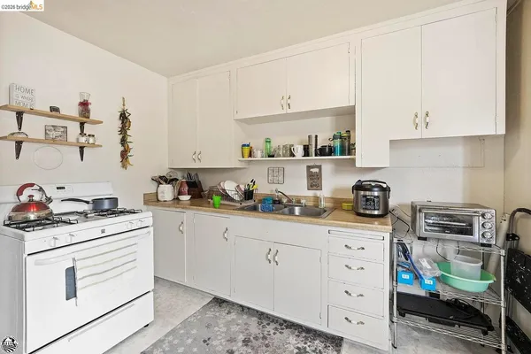 a kitchen with stainless steel appliances a stove a sink and white cabinets