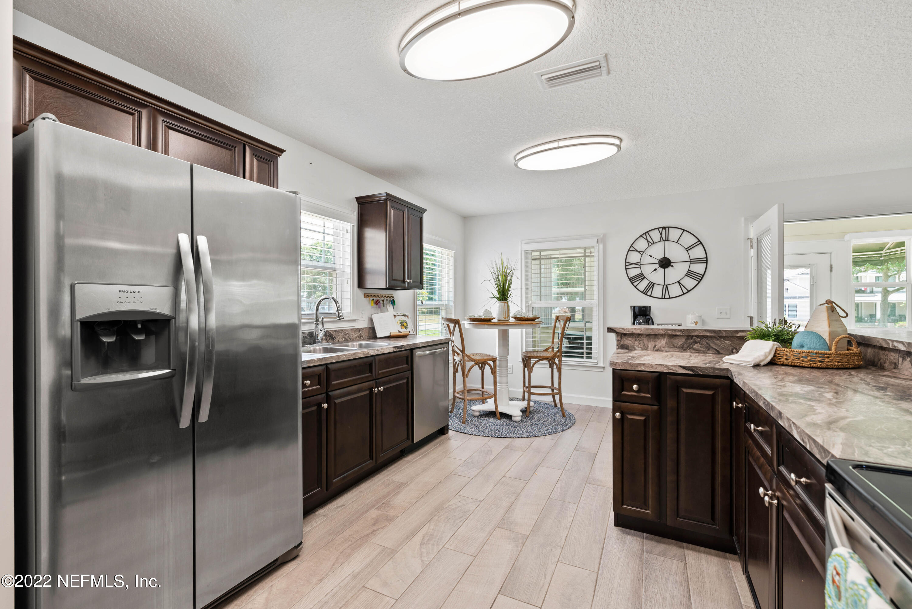 6434 Cabana Trace Starke, FL 32091 - Photo 13 of 38 a kitchen with stainless steel appliances granite countertop a refrigerator a sink dishwasher a stove with wooden cabinets and floor