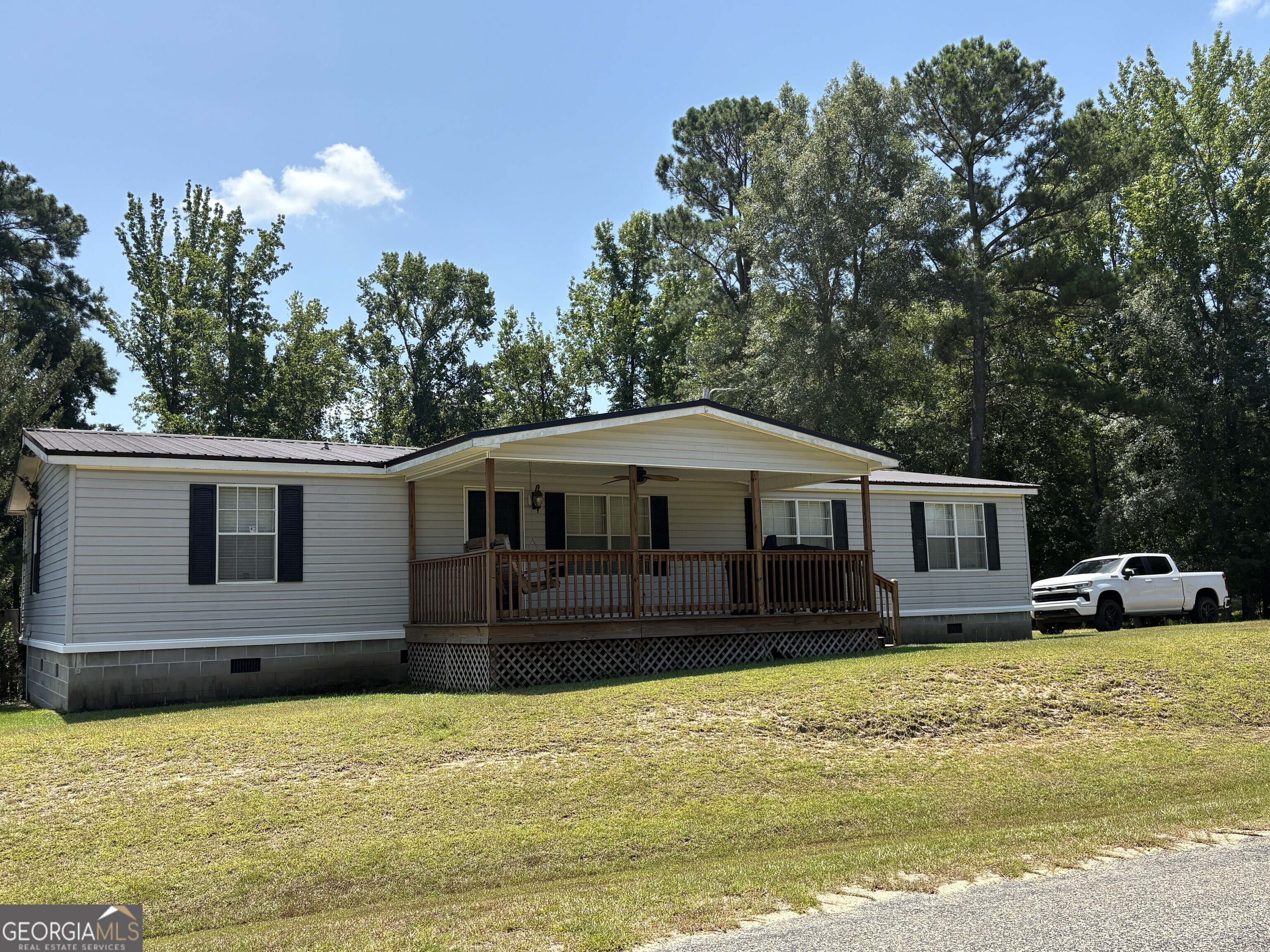 314 Cedar Creek Road Harrison, GA 31035 - Photo 2 of 20 a front view of a house with a yard and garage