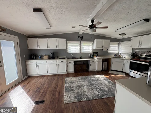 a kitchen with stainless steel appliances kitchen island granite countertop a stove sink and cabinets