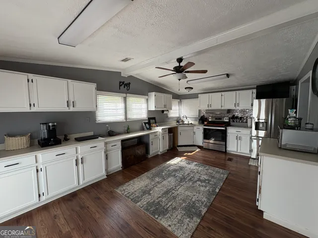 a large kitchen with cabinets wooden floor and stainless steel appliances