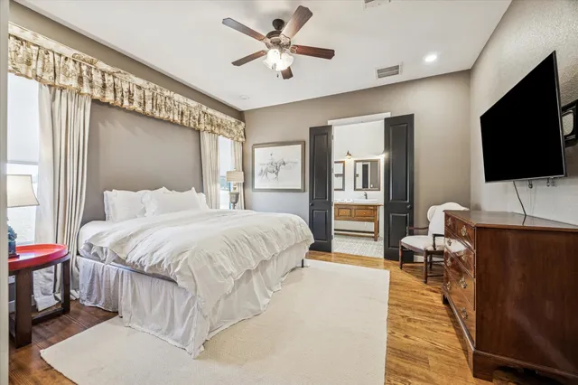 a spacious bedroom with a bed and a flat screen tv