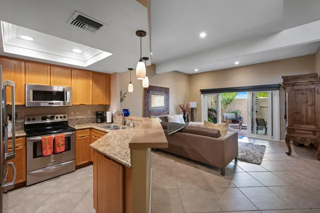 a large kitchen with stainless steel appliances granite countertop a stove and refrigerator