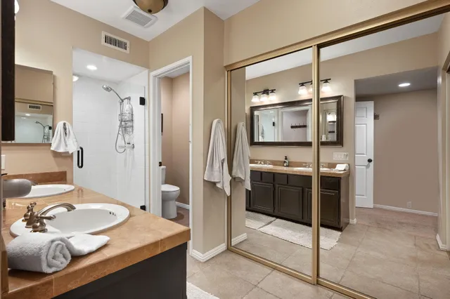 a spacious bathroom with a granite countertop sink mirror and toilet