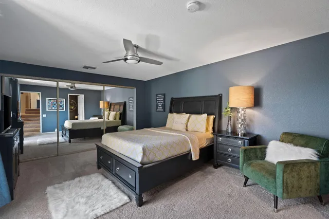 a bedroom with a large bed and a flat tv screen on dresser