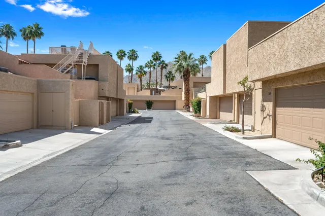 a view of a swimming pool with lounge chairs on a patio
