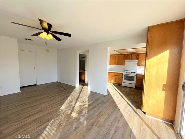 a kitchen with stainless steel appliances granite countertop a refrigerator a stove and a wooden floors