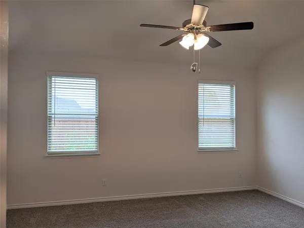 an empty room with a window and a fan