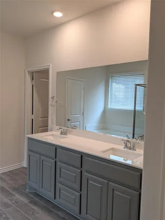 a bathroom with a double vanity sink and a mirror
