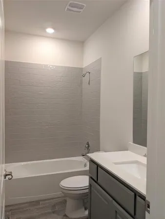 a bathroom with a granite countertop sink a toilet and shower