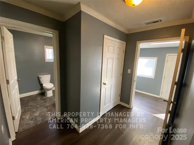 a view of a room with wooden floor and a bathroom