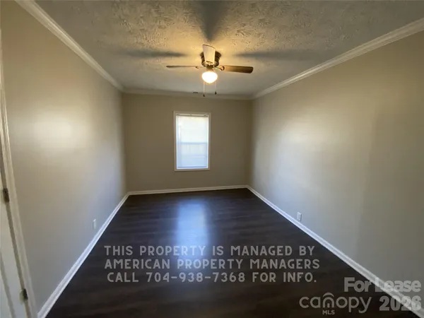 a view of a room with a ceiling fan and window