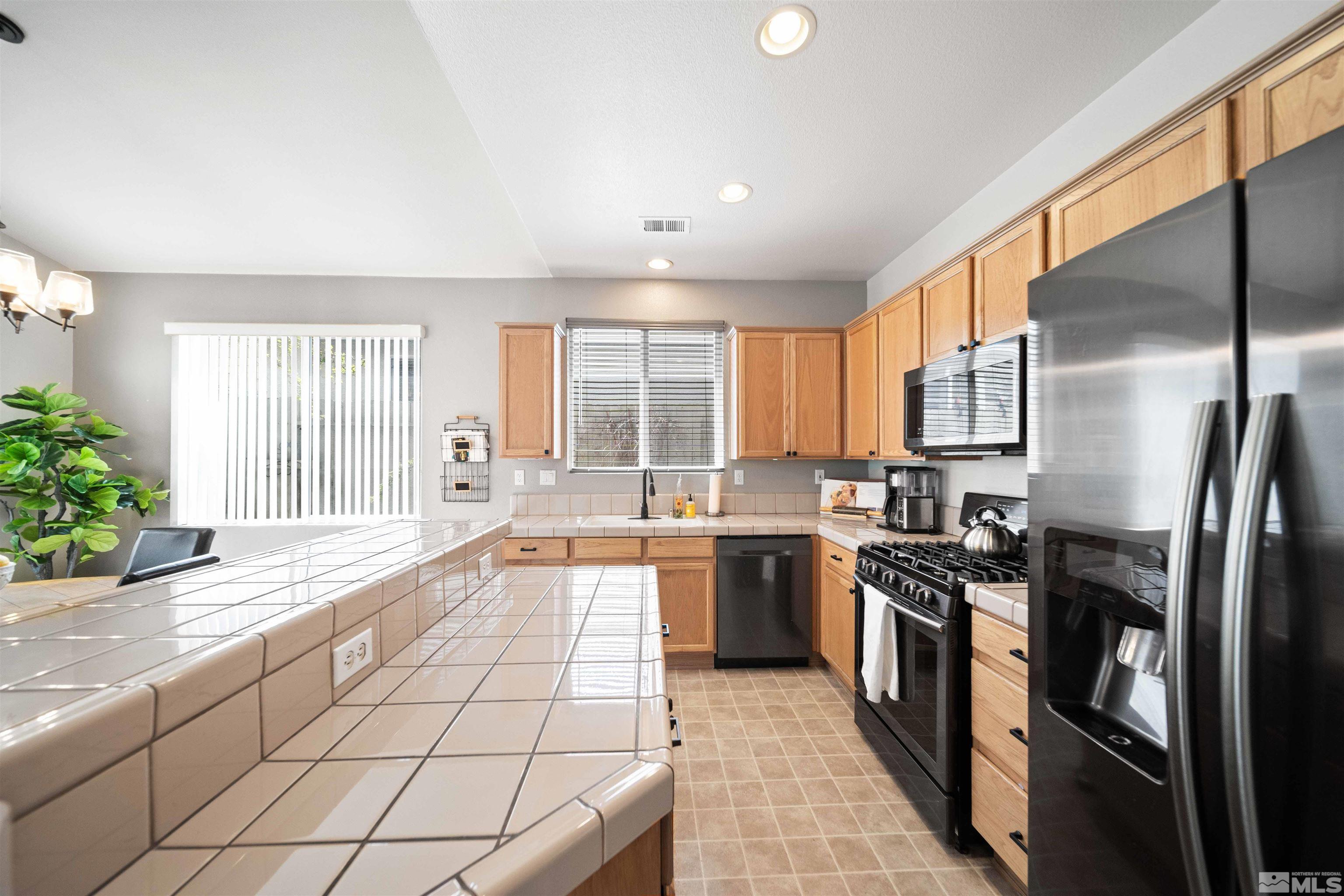 10599 Iron Point Circle Reno, NV 89521 - Photo 11 of 39 a large kitchen with stainless steel appliances lots of counter space and wooden floor