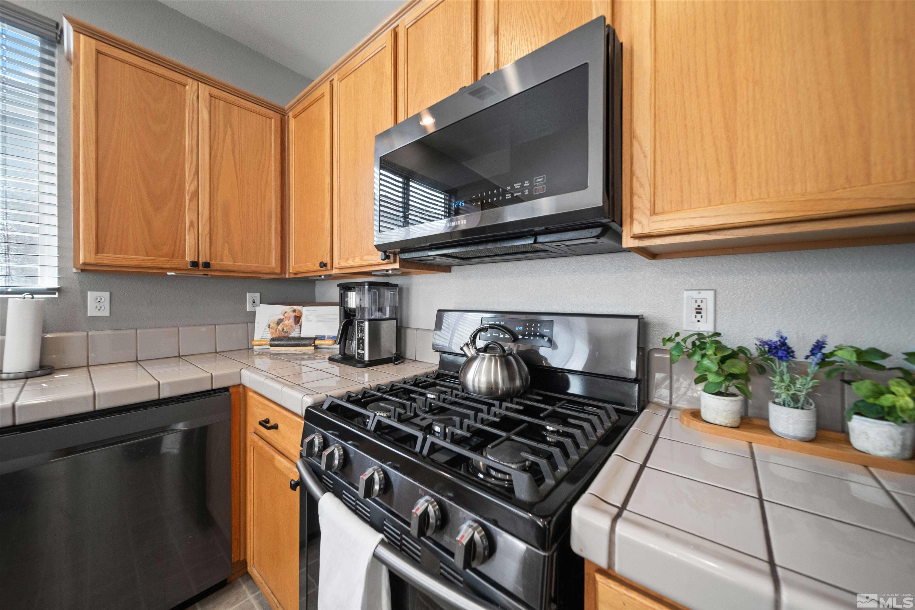 10599 Iron Point Circle Reno, NV 89521 - Photo 12 of 39 a kitchen with stainless steel appliances granite countertop a stove a microwave and sink