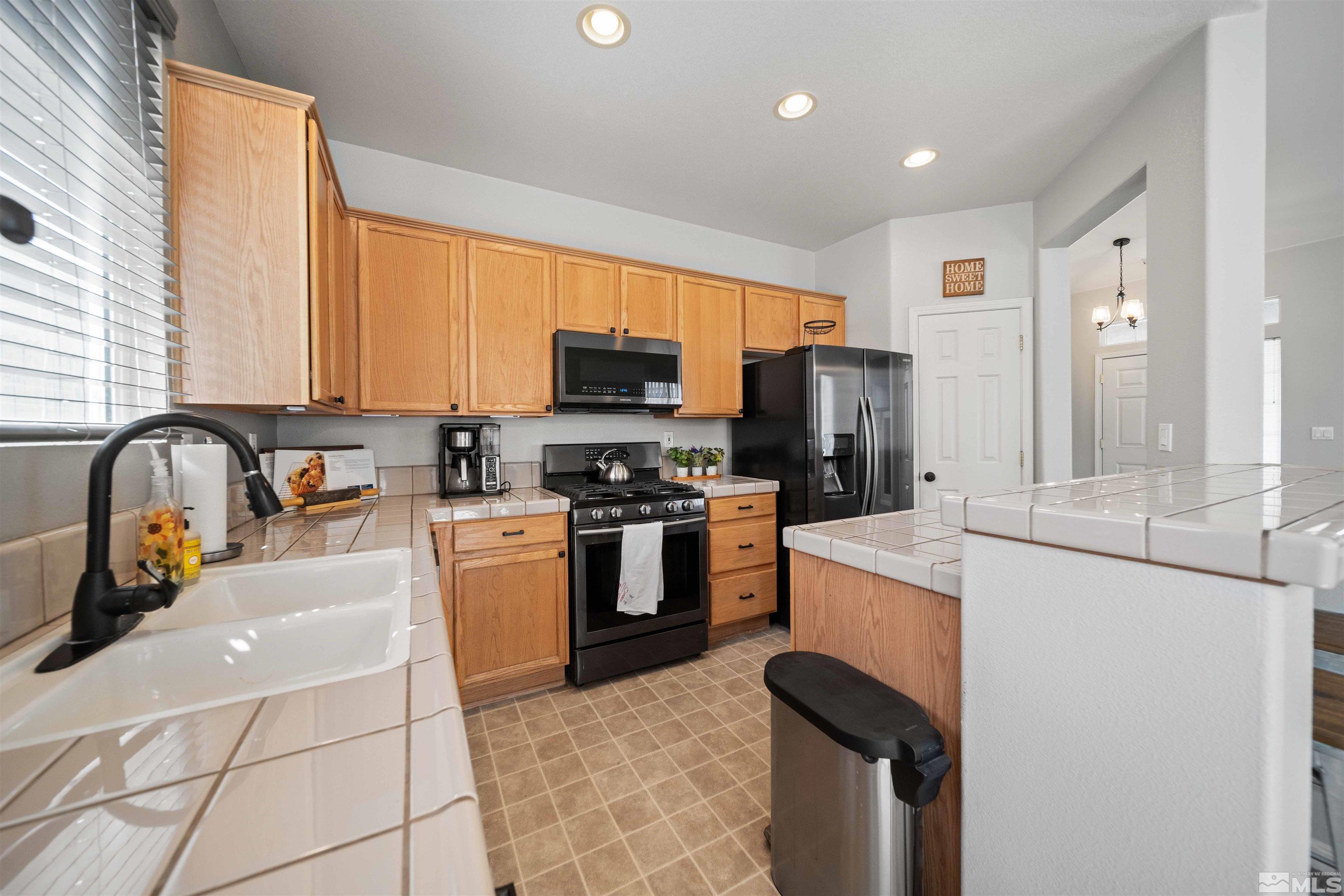 10599 Iron Point Circle Reno, NV 89521 - Photo 13 of 39 a kitchen with stainless steel appliances granite countertop a stove a sink and a microwave