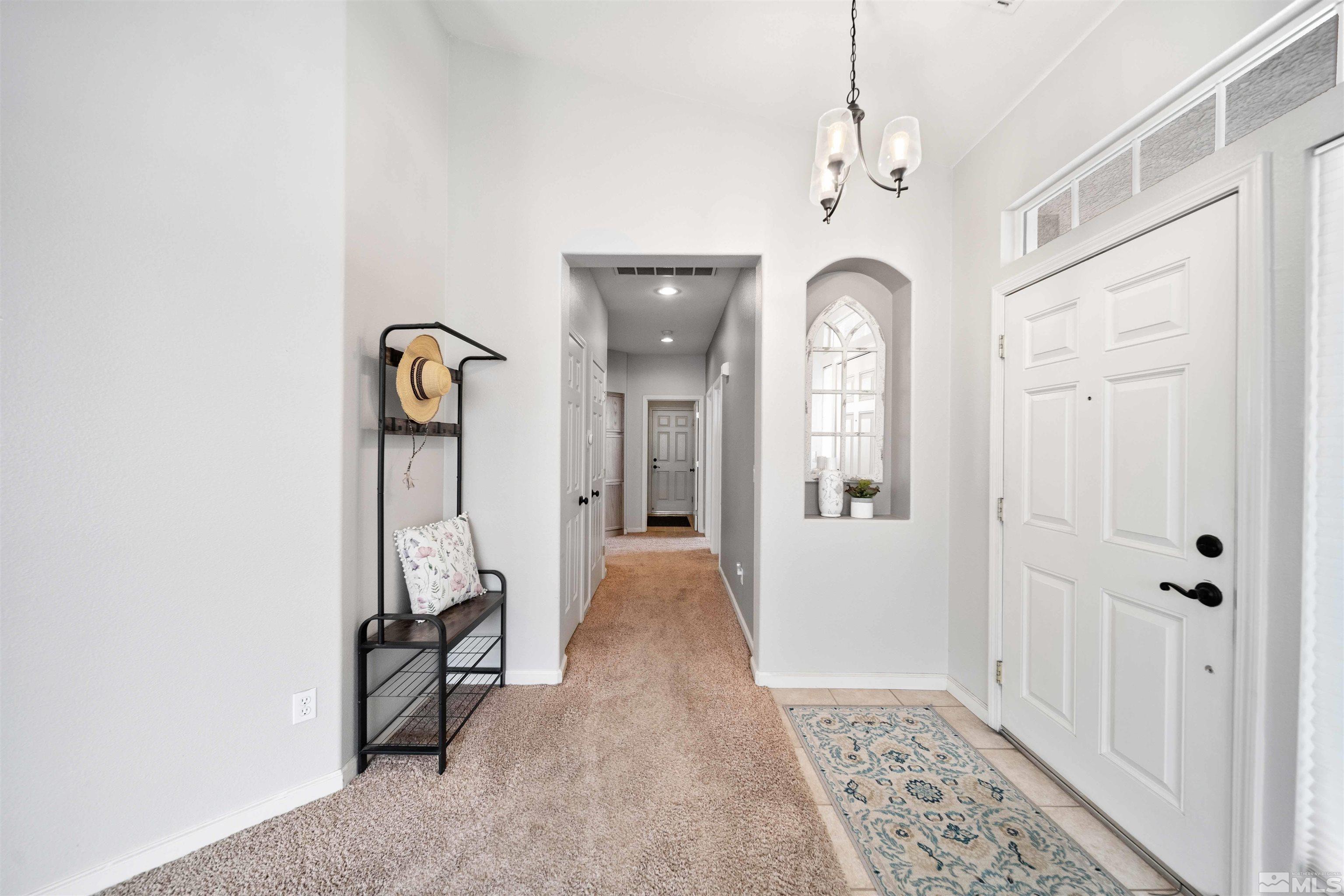 10599 Iron Point Circle Reno, NV 89521 - Photo 15 of 39 a view of a hallway with wooden floor and a chandelier
