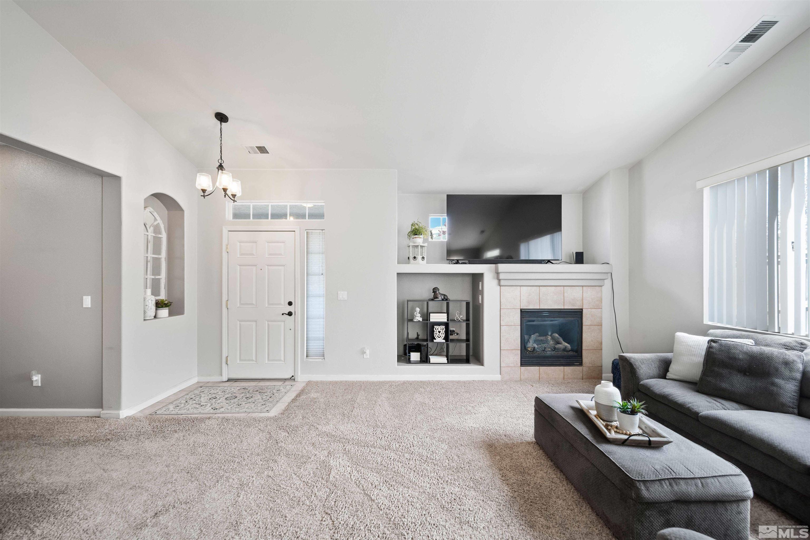 10599 Iron Point Circle Reno, NV 89521 - Photo 7 of 39 a living room with furniture a fireplace and a flat screen tv