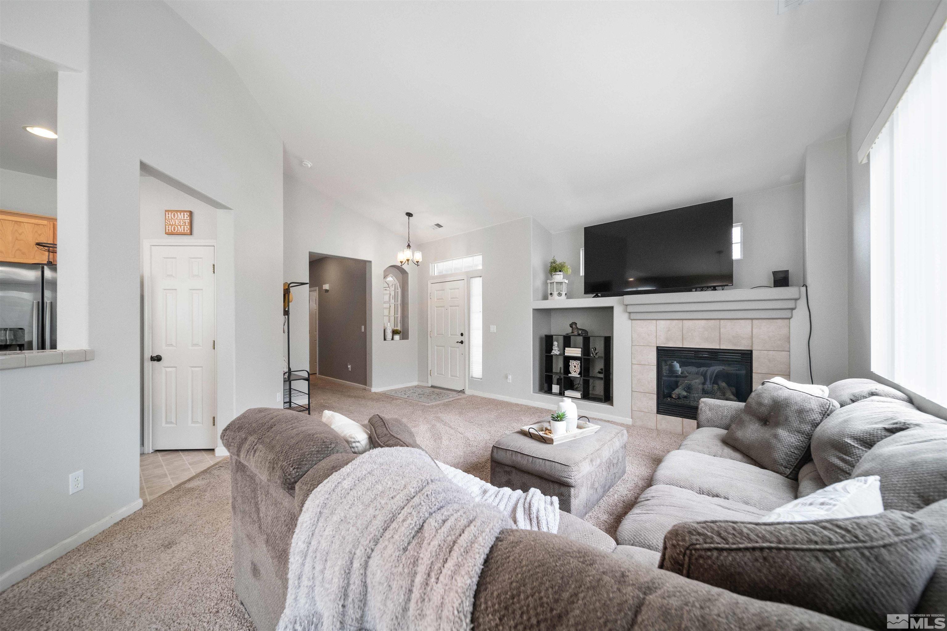 10599 Iron Point Circle Reno, NV 89521 - Photo 8 of 39 a living room with furniture a fireplace and a flat screen tv