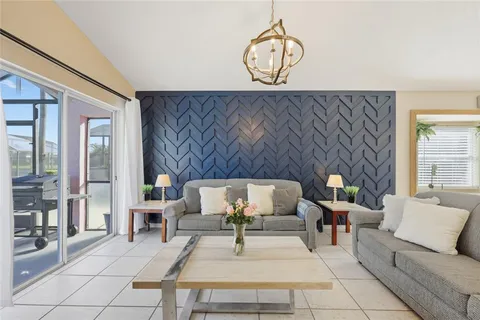 a living room with furniture a dining table and a chandelier