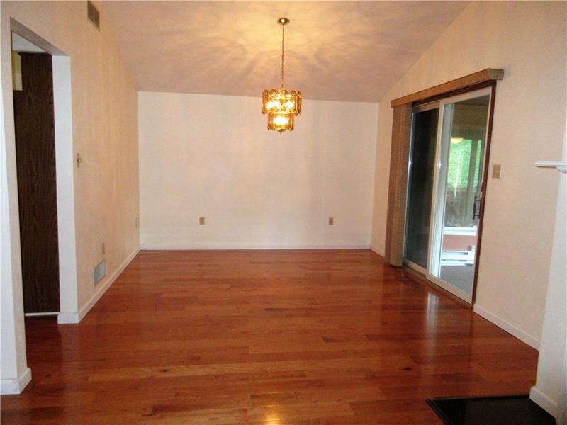 242 Boyd Road Freeport, PA 16229 - Photo 4 of 25 New hardwood floors, fresh paint, a cathedral ceiling, and sliding glass doors that lead to the 4 season room and covered side deck and fenced in side yard, make this dining room a lovely space to entertain guests.