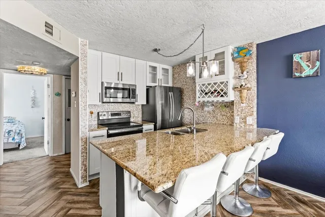 a kitchen with stainless steel appliances granite countertop a sink and refrigerator