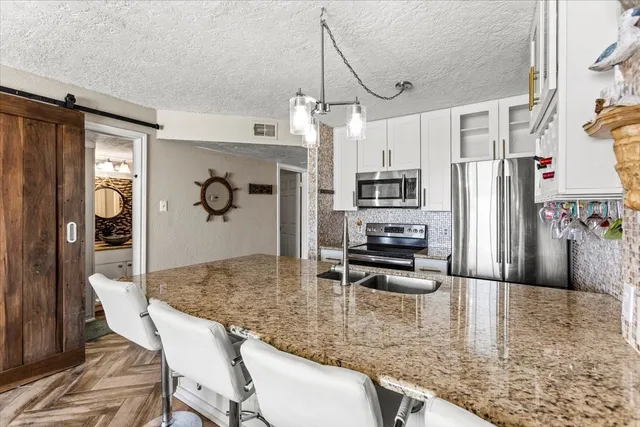 a kitchen with stainless steel appliances granite countertop a sink refrigerator and microwave