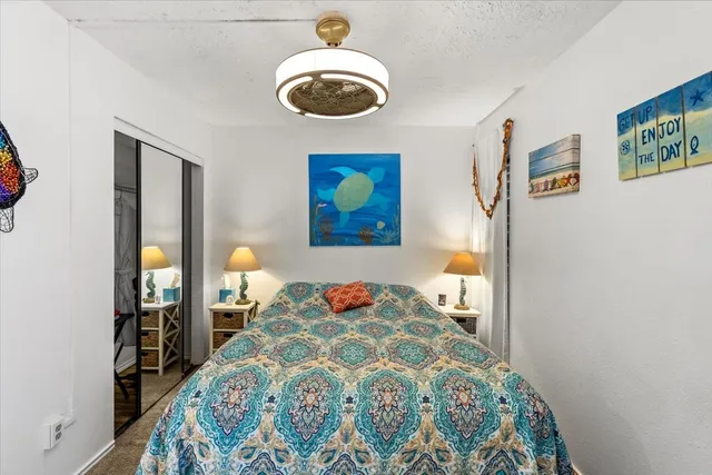 a bedroom with a bed and a painting on the wall